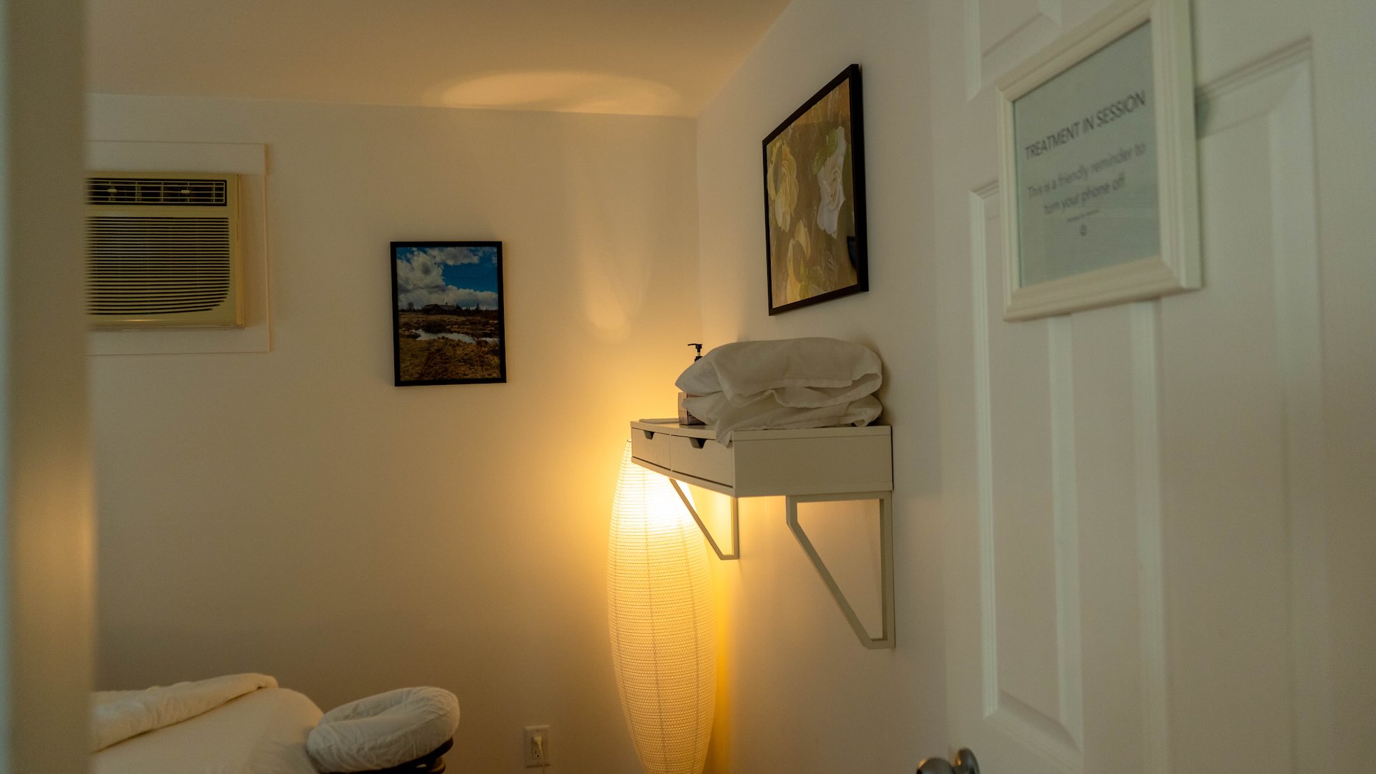 Massage treatment room doorway with 'treatment in session' sign